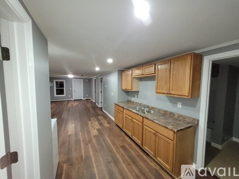 A kitchen with wooden cabinets and a countertop is available for rent.