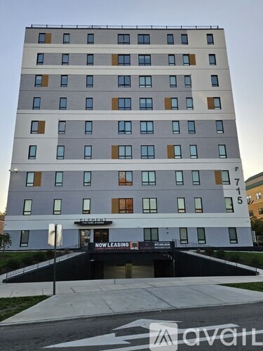 A tall building with a sign that says "The Heights" and "Now Leasing" in front of it.