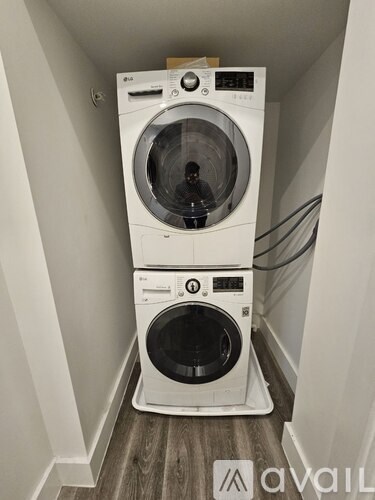 A stacked washer and dryer in a narrow hallway.
