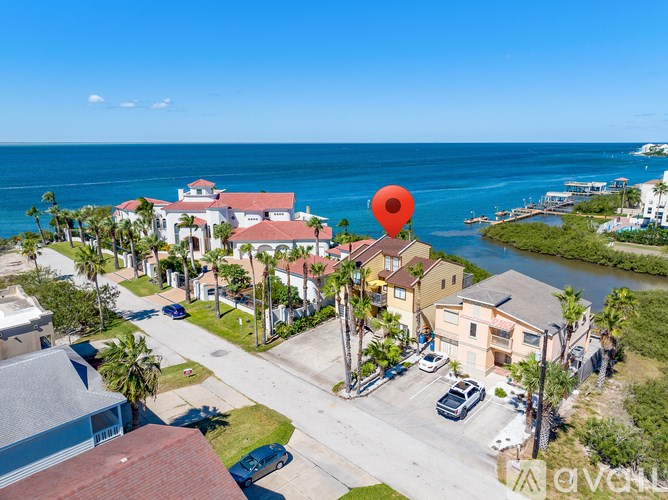 A bird's eye view of a coastal neighborhood with a red pin on a house.