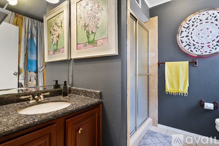 A bathroom with a sink, mirror, and a yellow towel hanging on the wall.