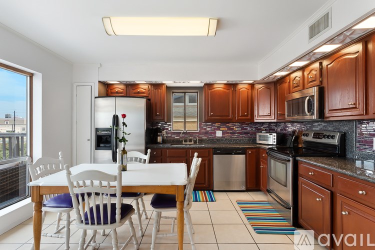 A kitchen with brown cabinets and a white table.
