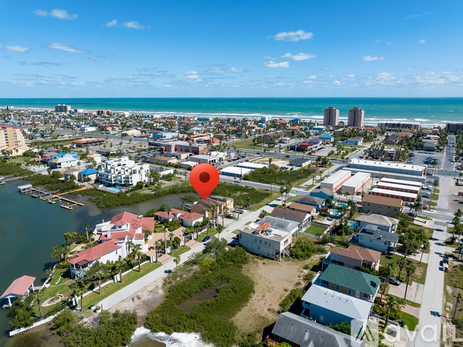 A red pin marks a location on a map of a coastal town.