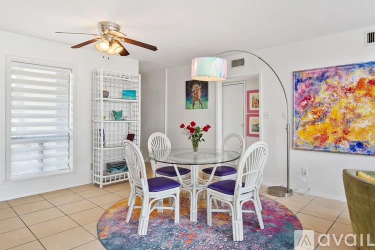 A dining room with a white table and chairs.