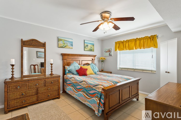 A bedroom with a bed, dresser, and mirror.