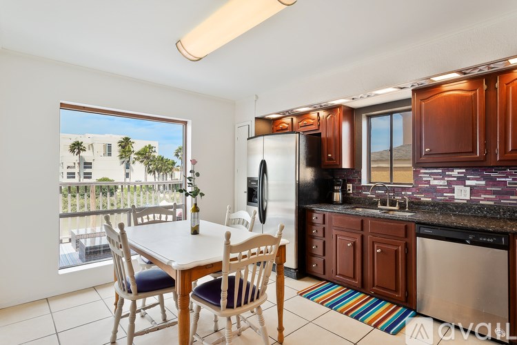 A kitchen with wooden cabinets and a white table.