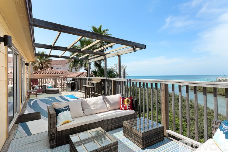 A patio with a couch and a table with a glass top.
