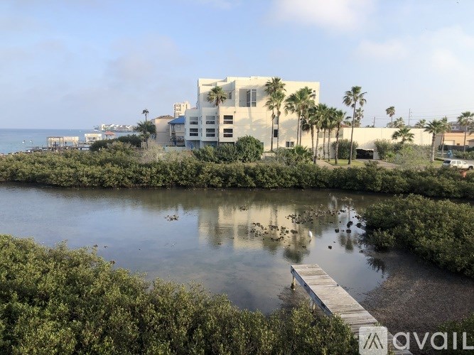 A building is situated by a body of water with a dock leading into it.
