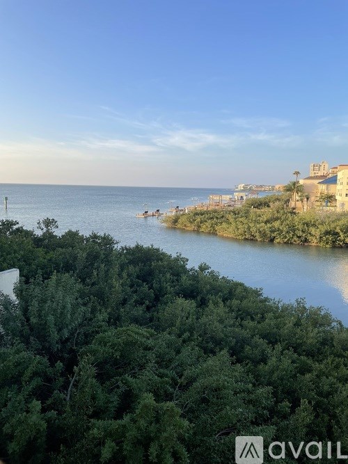 A view of a body of water surrounded by trees and buildings in the distance.