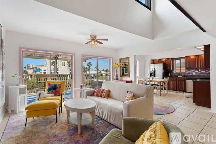 A living room with a white couch and a yellow chair.