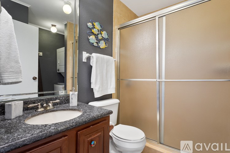 A bathroom with a toilet, sink, mirror, and a towel hanging on the wall.