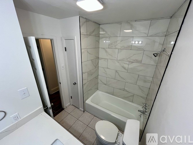 A bathroom with a white tub and toilet.