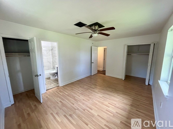 A room with wooden flooring and a ceiling fan.