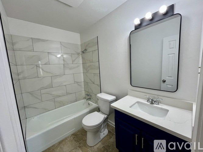 A bathroom with a white toilet, a white sink, and a white bathtub.