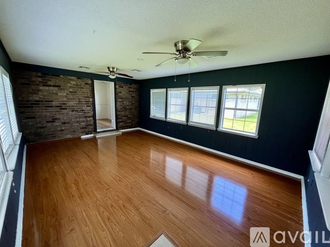 A room with wooden floors and a ceiling fan.