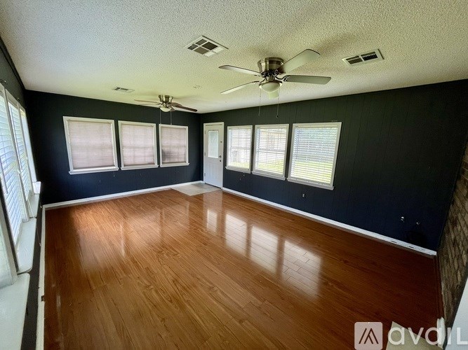 A room with wooden floors and a ceiling fan.