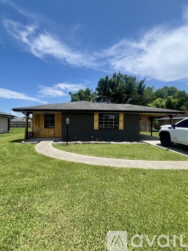A house with a dark roof and a white car parked in front.