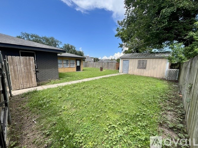 A backyard with a wooden fence and a shed.