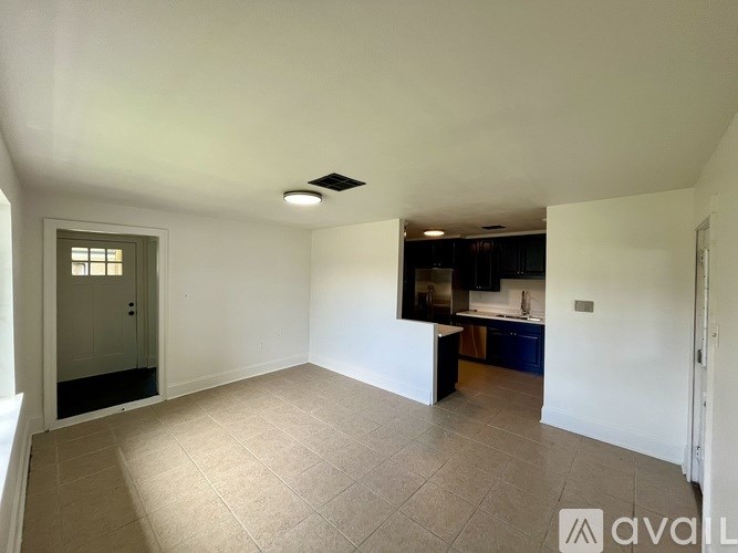 A spacious room with a tiled floor and a ceiling fan.