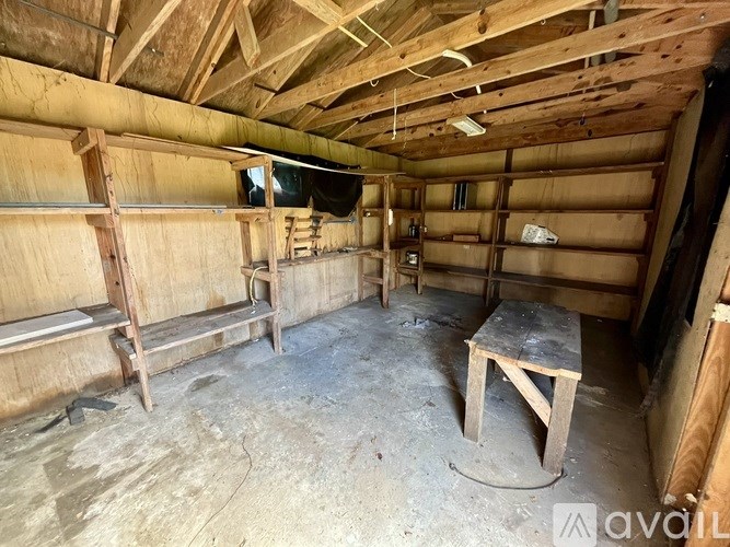 A wooden cabin with a table and benches inside.