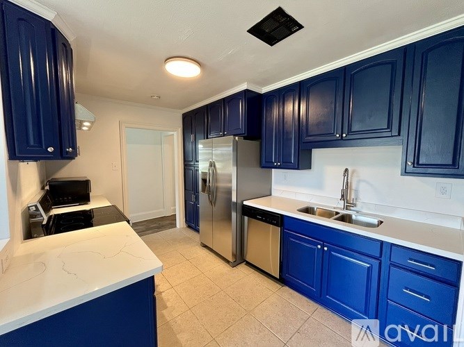 A kitchen with blue cabinets and a white counter.