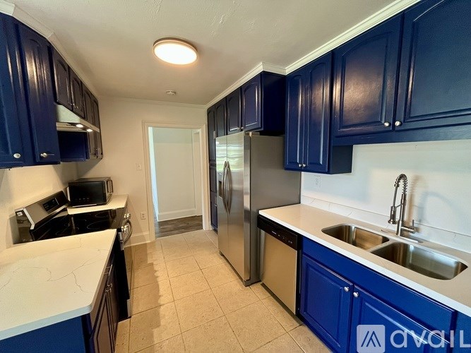 A kitchen with blue cabinets and a white counter.