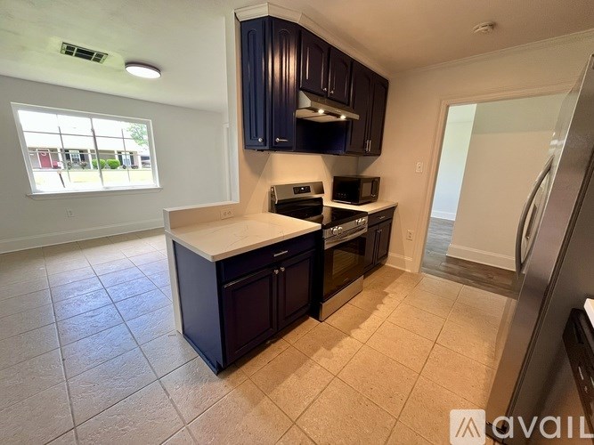 A kitchen with dark brown cabinets and a white countertop.
