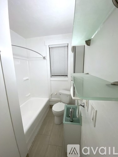 A small bathroom with a toilet, sink and bathtub.