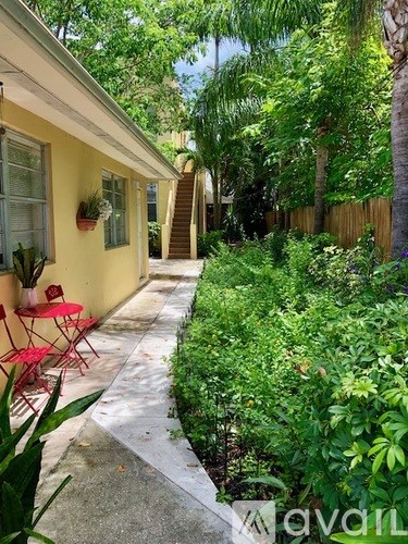 A yellow house with a red chair outside.