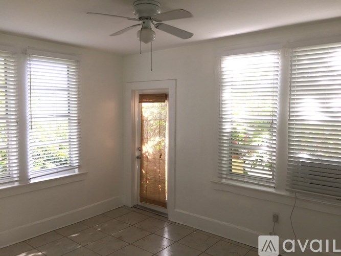 A room with a ceiling fan and a door with a glass window.