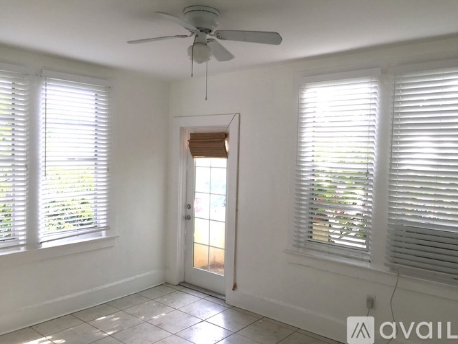 A room with a ceiling fan and two windows with blinds.