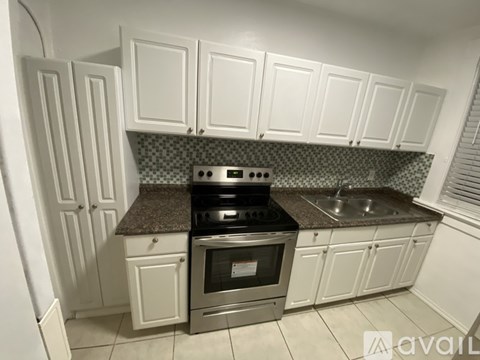 A kitchen with white cabinets and a granite countertop.