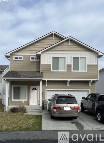 A two-story house with a garage and a car parked in front.