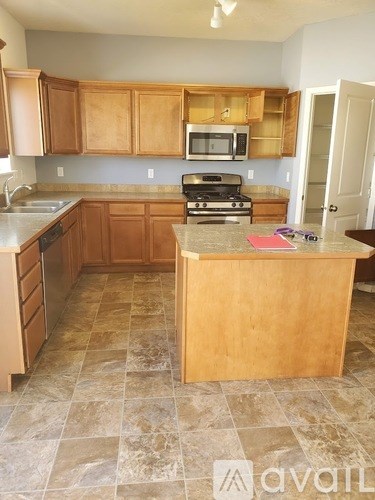 A kitchen with wooden cabinets and a tiled floor.