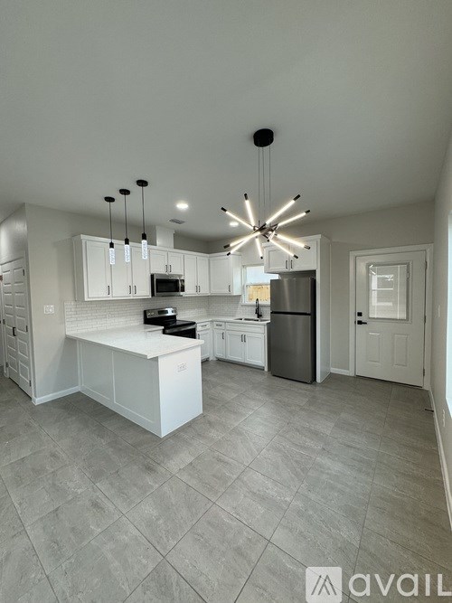 A modern kitchen with a large island and a refrigerator.
