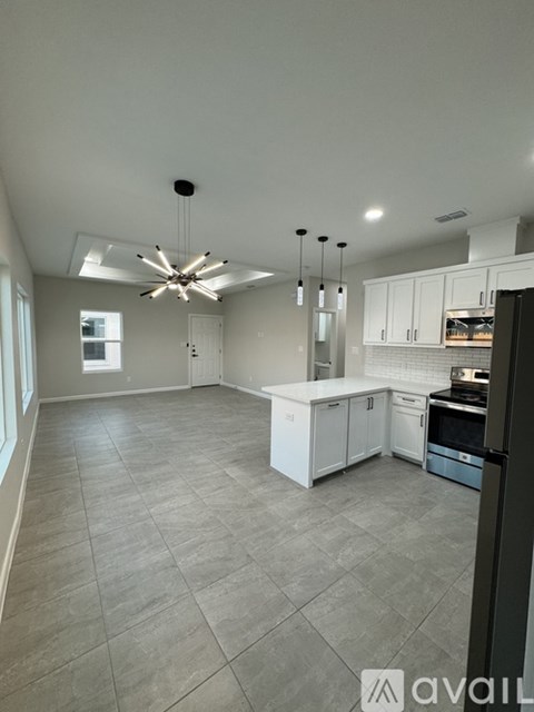 A kitchen with white cabinets and a tiled floor.