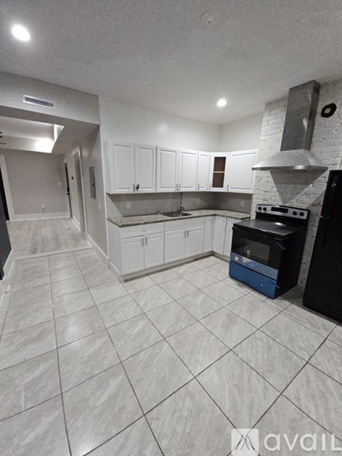 A kitchen with white cabinets and a black oven.