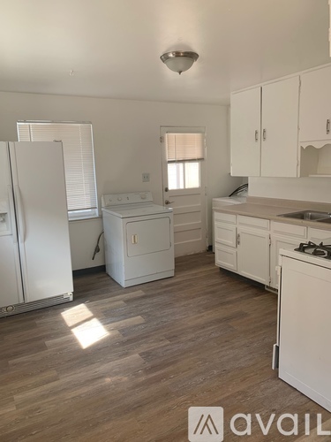 A kitchen with white appliances and cabinets.