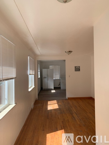 A long hallway with wood floors and white walls.