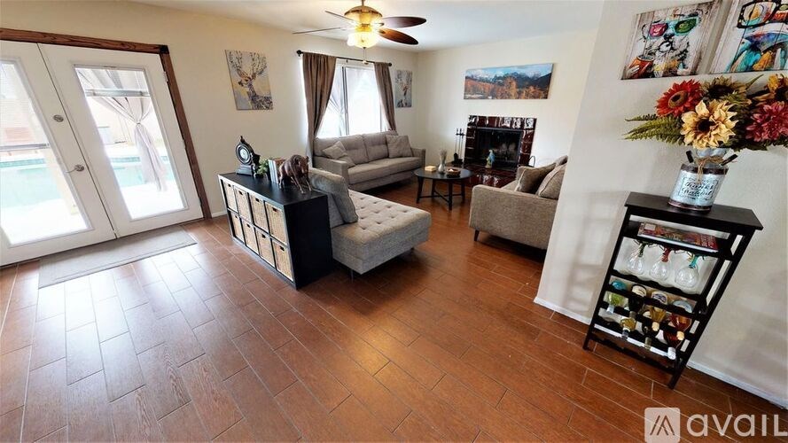 A living room with a couch, chair, and a table with a vase of flowers on it.