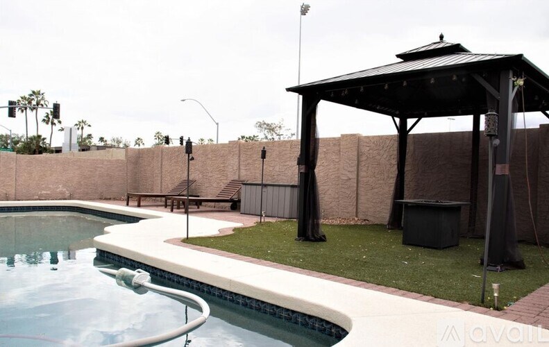A pool with a pavilion and a fence.