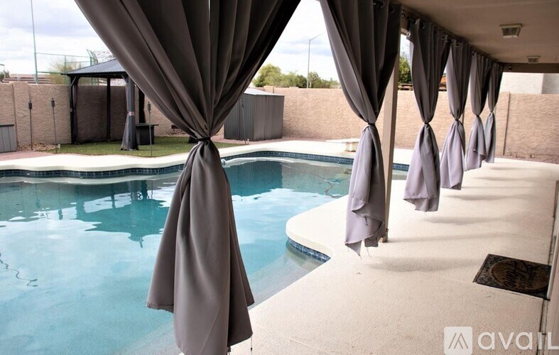A pool area with a row of umbrellas and a drain in the pool.