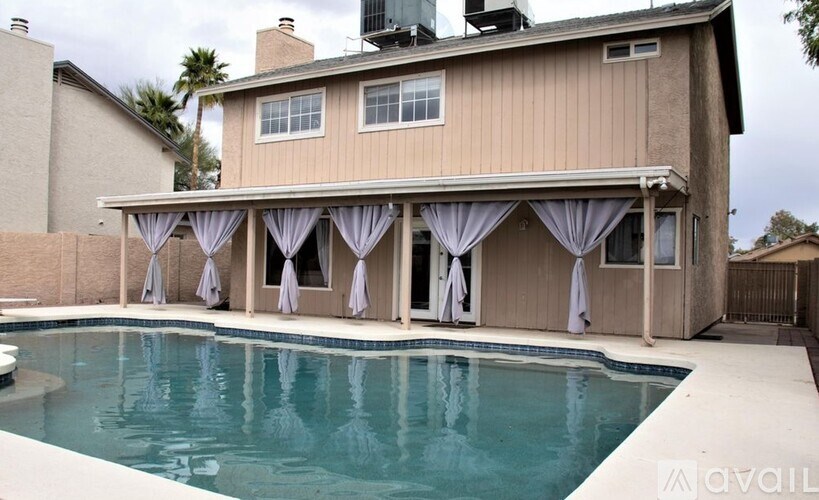 A house with a pool in front of it.