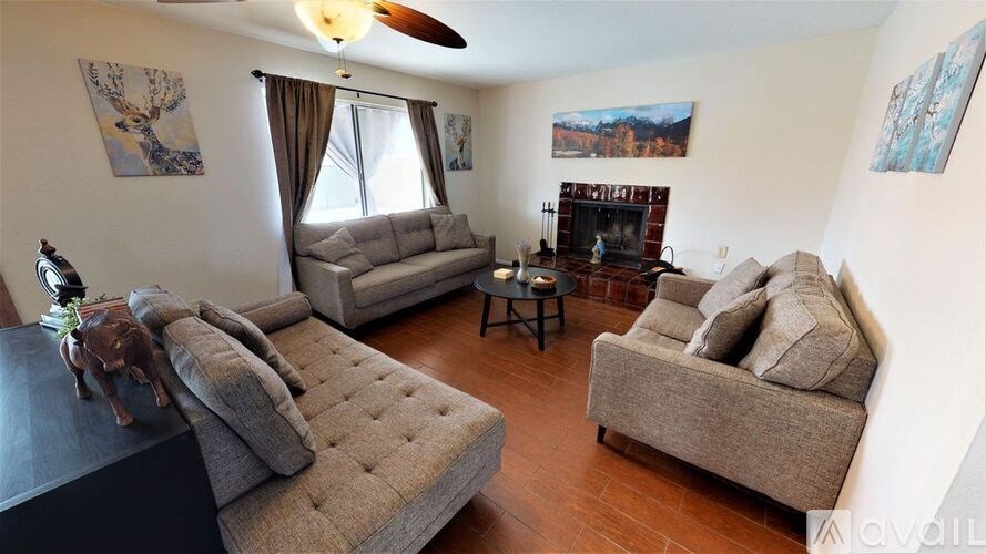 A living room with a grey sofa and a black coffee table.