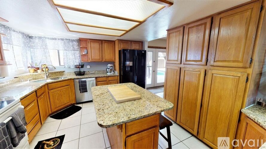 A kitchen with wooden cabinets and a granite countertop.
