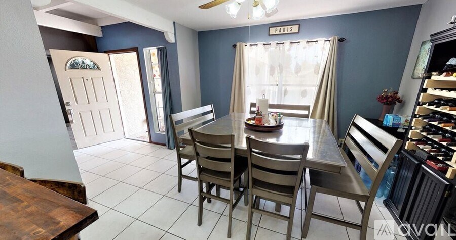 A dining room with a table set for four.