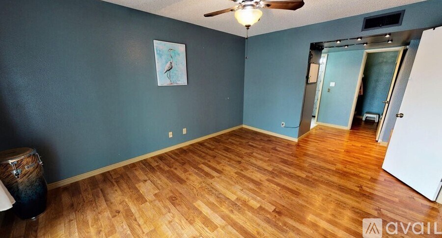 A room with wooden flooring and a ceiling fan.