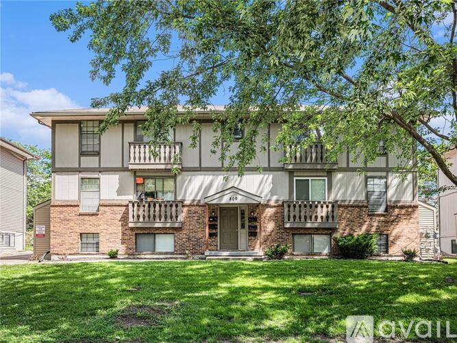 A two-story brick apartment building with a balcony on the second floor.