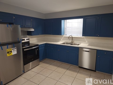 A kitchen with blue cabinets and a stainless steel refrigerator.