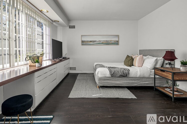 A bedroom with a bed, desk, and chair.